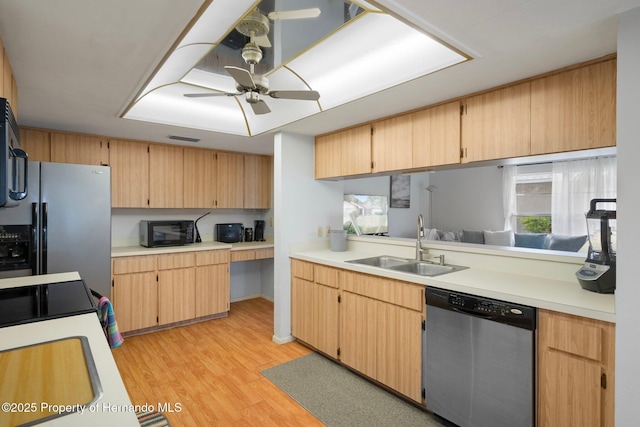 kitchen featuring a sink, light wood-style floors, light countertops, fridge with ice dispenser, and stainless steel dishwasher