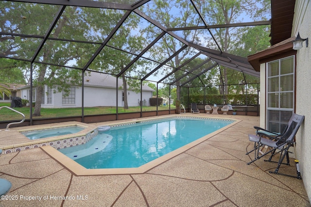 view of swimming pool featuring glass enclosure, a pool with connected hot tub, and a patio area