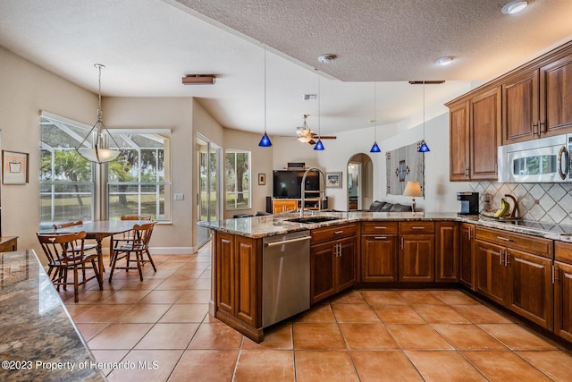 3011 Endsley Rd, Brooksville, FL 34604 - kitchen with a peninsula, a sink, stainless steel appliances, decorative backsplash, and light tile patterned flooring