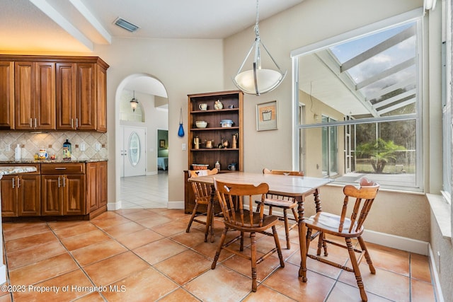 3011 Endsley Rd, Brooksville, FL 34604 - dining area featuring a skylight, visible vents, baseboards, arched walkways, and light tile patterned flooring