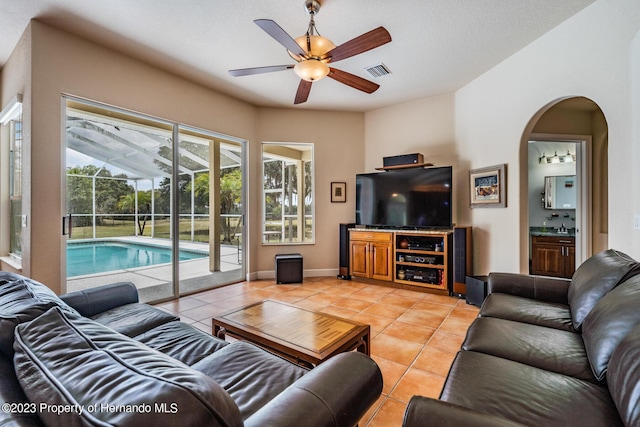 3011 Endsley Rd, Brooksville, FL 34604 - living area with a ceiling fan, baseboards, light tile patterned floors, visible vents, and arched walkways