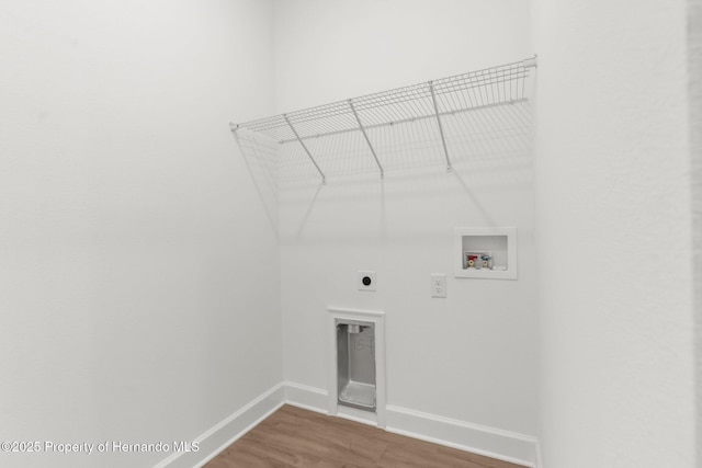 14042 Amero Ln, Spring Hill, FL 34609 - laundry room featuring wood finished floors, electric dryer hookup, laundry area, washer hookup, and baseboards