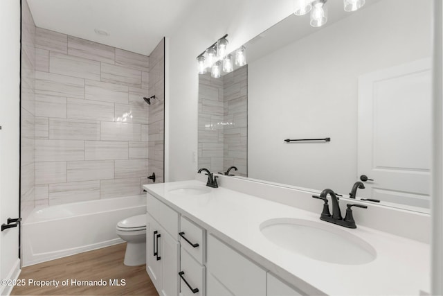 14042 Amero Ln, Spring Hill, FL 34609 - bathroom featuring double vanity, toilet, wood finished floors, and a sink