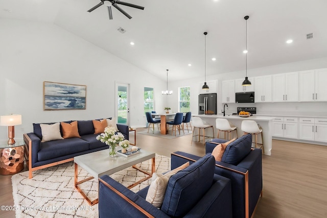 14042 Amero Ln, Spring Hill, FL 34609 - living room with recessed lighting, visible vents, ceiling fan with notable chandelier, high vaulted ceiling, and light wood-type flooring