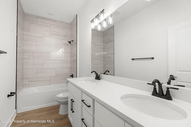 14042 Amero Ln, Spring Hill, FL 34609 - full bathroom with double vanity, toilet, wood finished floors, and a sink