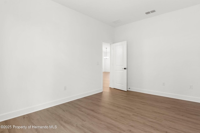 14042 Amero Ln, Spring Hill, FL 34609 - empty room featuring visible vents, wood finished floors, and baseboards