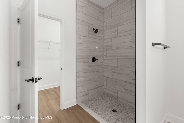 14042 Amero Ln, Spring Hill, FL 34609 - full bath featuring a tile shower, a spacious closet, baseboards, and wood finished floors