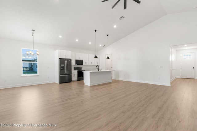 14042 Amero Ln, Spring Hill, FL 34609 - unfurnished living room featuring light wood finished floors, ceiling fan with notable chandelier, a sink, high vaulted ceiling, and visible vents