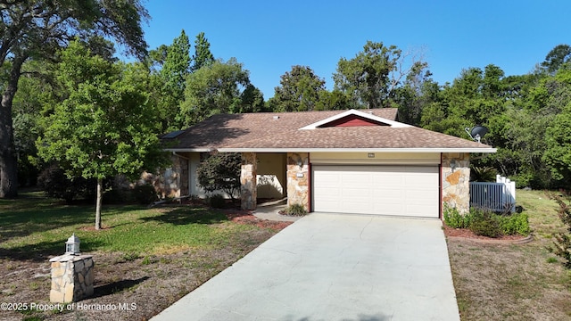 single story home with driveway, a front lawn, an attached garage, a shingled roof, and stone siding