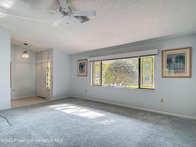 unfurnished room featuring carpet floors, a textured ceiling, baseboards, and ceiling fan