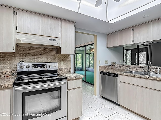 kitchen featuring a sink, stainless steel appliances, a ceiling fan, backsplash, and under cabinet range hood