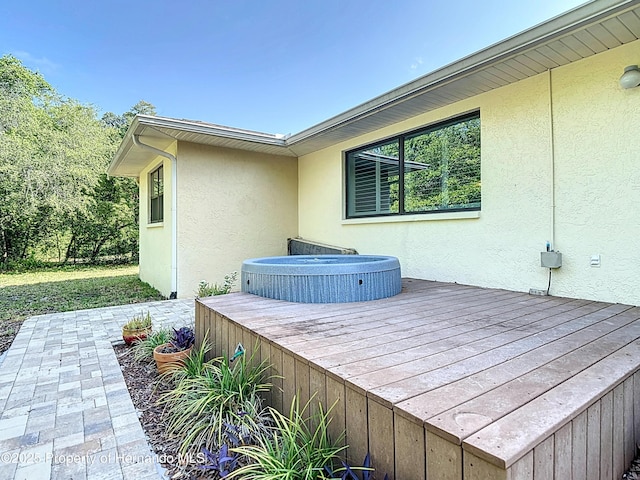 deck featuring an outdoor hot tub