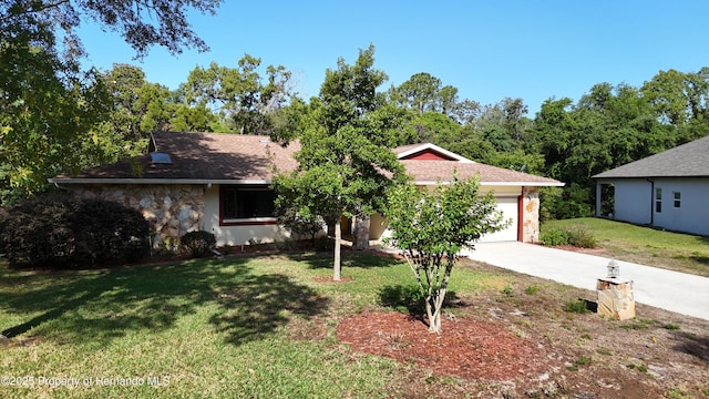 view of front of home featuring a garage, stone siding, a front yard, stucco siding, and driveway