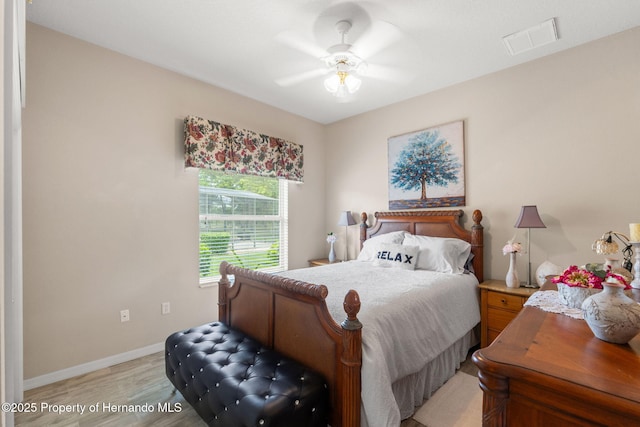 bedroom featuring visible vents, light wood-style flooring, ceiling fan, and baseboards