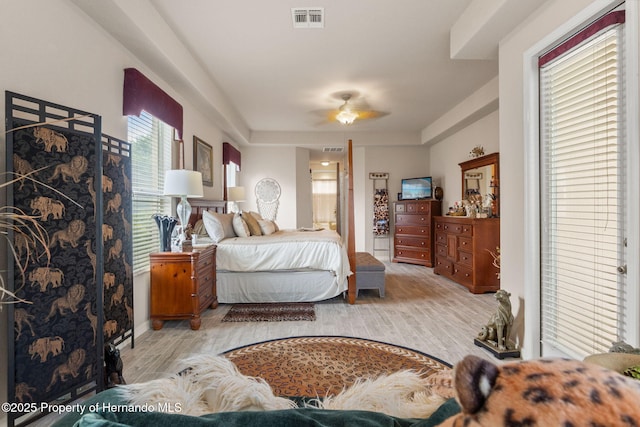 bedroom featuring visible vents, wood finished floors, and ensuite bathroom