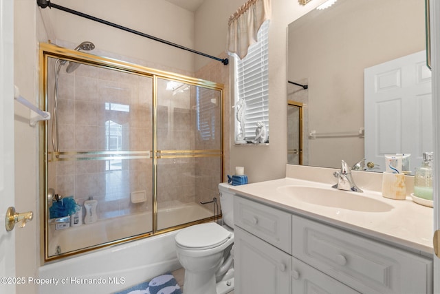bathroom with toilet, enclosed tub / shower combo, and vanity