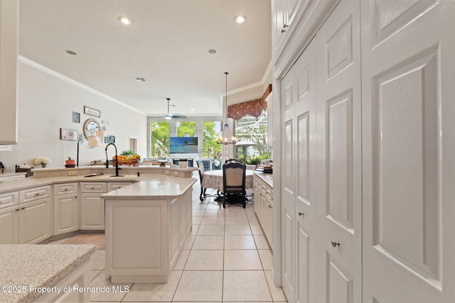 kitchen featuring crown molding, recessed lighting, white cabinetry, a sink, and light tile patterned floors