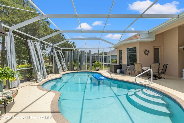 pool featuring glass enclosure and a patio