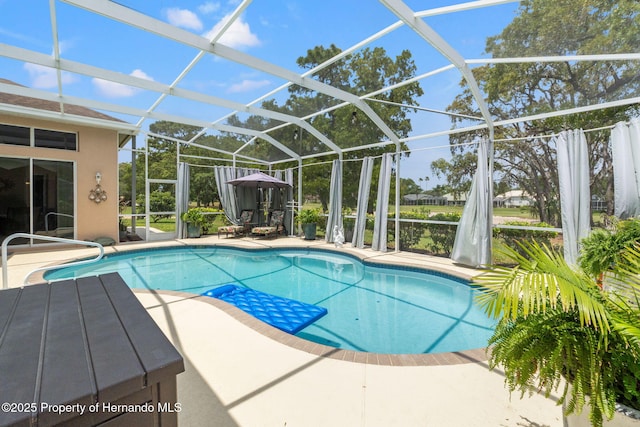 outdoor pool with glass enclosure and a patio area