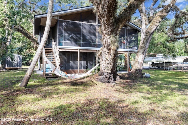 6373 E River Rd, Hernando, FL 34442 - rear view of house featuring stairway, a lawn, and a sunroom