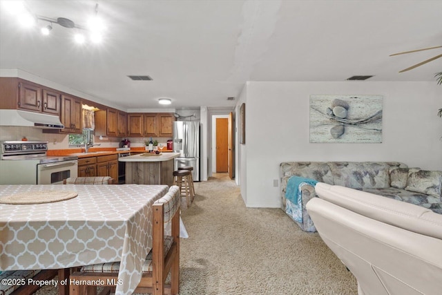 6373 E River Rd, Hernando, FL 34442 - kitchen with range with electric stovetop, light colored carpet, dishwasher, stainless steel fridge, and under cabinet range hood