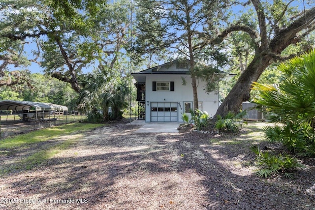 6373 E River Rd, Hernando, FL 34442 - view of property exterior featuring fence, a detached carport, an attached garage, and driveway