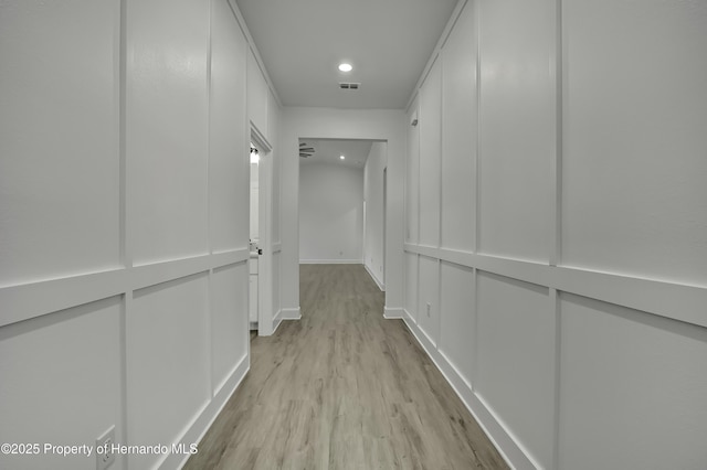 hallway with recessed lighting, baseboards, visible vents, and light wood finished floors