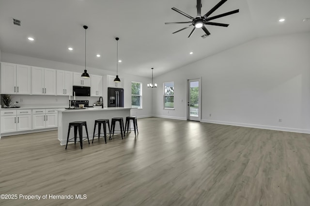 kitchen featuring recessed lighting, open floor plan, black appliances, and ceiling fan with notable chandelier