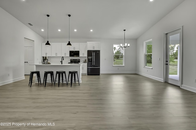 kitchen with recessed lighting, baseboards, light wood finished floors, and black appliances