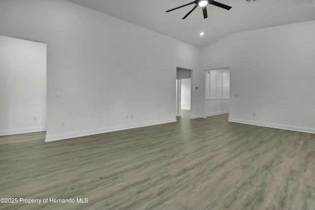 empty room with visible vents, wood finished floors, baseboards, high vaulted ceiling, and a ceiling fan