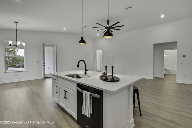 kitchen with visible vents, open floor plan, dishwashing machine, a sink, and light wood finished floors