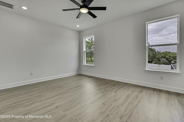 unfurnished room with a ceiling fan, baseboards, recessed lighting, wood finished floors, and visible vents