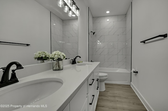 bathroom with double vanity, toilet, a sink, and wood finished floors
