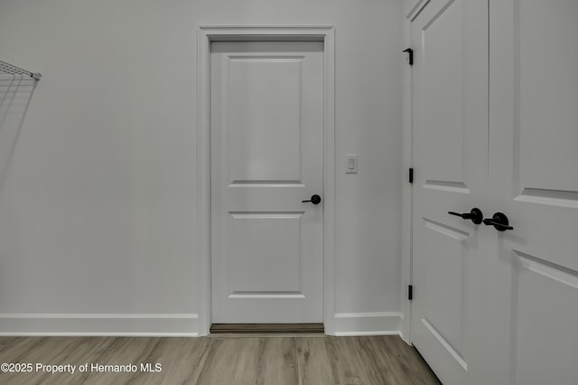 interior space with baseboards and light wood-style flooring