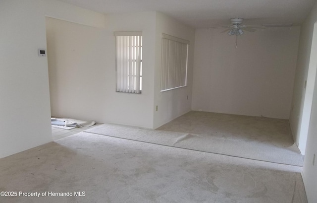 carpeted spare room featuring a ceiling fan