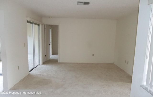 spare room featuring carpet flooring and visible vents