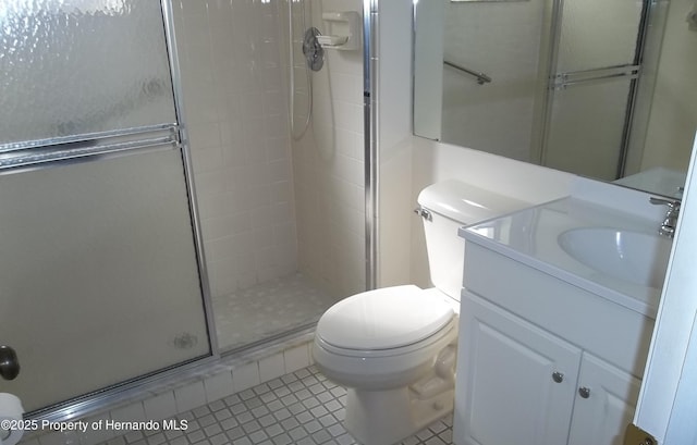 bathroom featuring vanity, tile patterned floors, a stall shower, and toilet