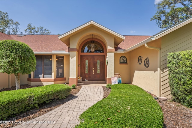 7353 Dogwood, Spring Hill, FL 34607 - doorway to property with french doors, stucco siding, and roof with shingles