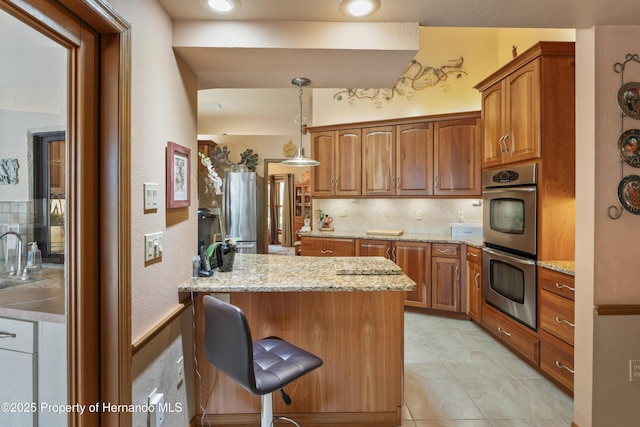 7353 Dogwood, Spring Hill, FL 34607 - kitchen featuring a sink, brown cabinets, a breakfast bar, and appliances with stainless steel finishes