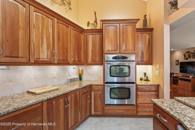 7353 Dogwood, Spring Hill, FL 34607 - kitchen with tasteful backsplash, stainless steel double oven, light stone countertops, and brown cabinetry