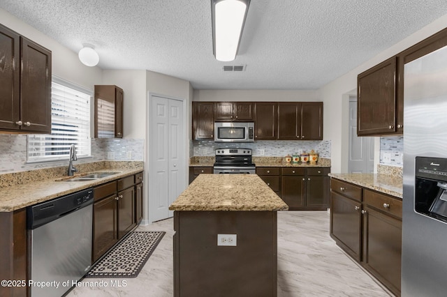 6440 Curtiss Ln, Spring Hill, FL 34608 - kitchen with appliances with stainless steel finishes, a sink, dark brown cabinets, backsplash, and a textured ceiling