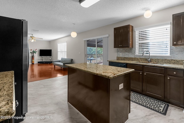 6440 Curtiss Ln, Spring Hill, FL 34608 - kitchen with freestanding refrigerator, a sink, a kitchen island, dark brown cabinetry, and open floor plan