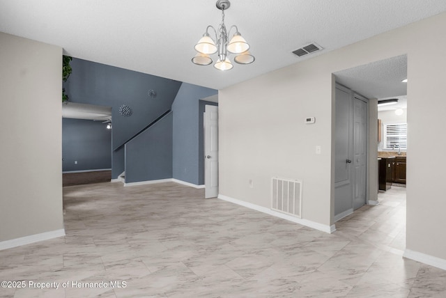 6440 Curtiss Ln, Spring Hill, FL 34608 - unfurnished room featuring light marble finish floors, a chandelier, baseboards, stairway, and a textured ceiling