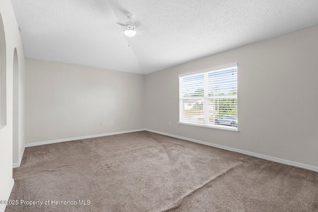 6440 Curtiss Ln, Spring Hill, FL 34608 - carpeted spare room with ceiling fan, baseboards, a textured ceiling, and lofted ceiling