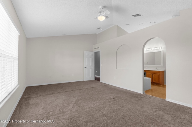6440 Curtiss Ln, Spring Hill, FL 34608 - spare room featuring light colored carpet, plenty of natural light, ceiling fan, baseboards, and high vaulted ceiling