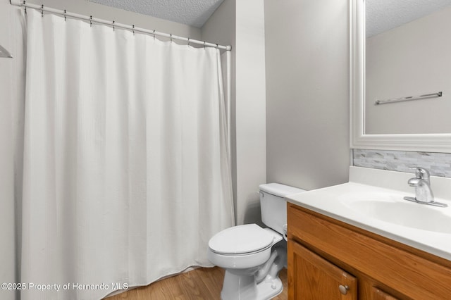 6440 Curtiss Ln, Spring Hill, FL 34608 - full bath with a textured ceiling, toilet, vanity, wood finished floors, and backsplash
