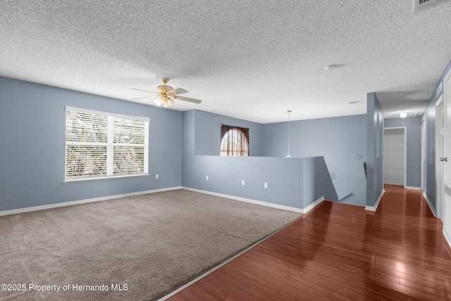 6440 Curtiss Ln, Spring Hill, FL 34608 - spare room with healthy amount of natural light, ceiling fan, wood finished floors, baseboards, and a textured ceiling