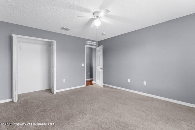 6440 Curtiss Ln, Spring Hill, FL 34608 - unfurnished bedroom with carpet flooring, a textured ceiling, a closet, and a ceiling fan