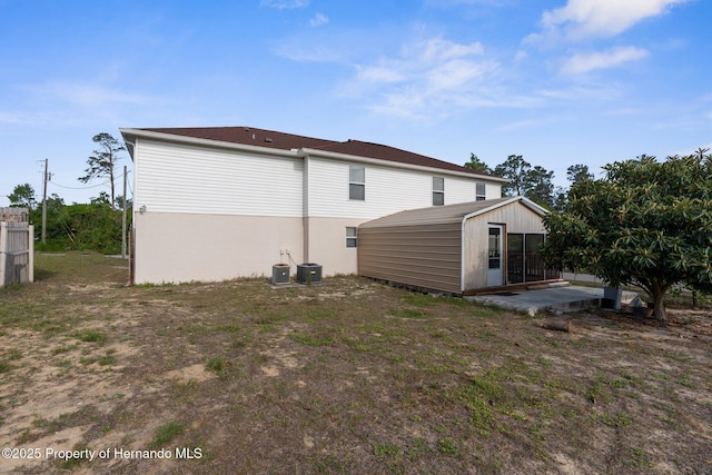 6440 Curtiss Ln, Spring Hill, FL 34608 - rear view of house featuring central AC and an outbuilding