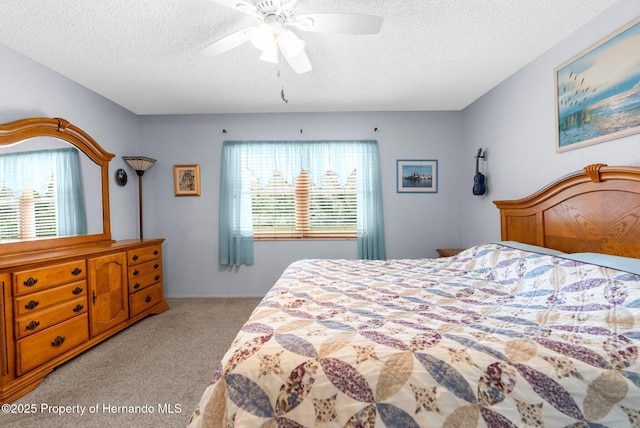 carpeted bedroom with a textured ceiling and a ceiling fan